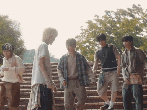 a group of young men are standing on a set of stairs and one of them has a sign that says " wanted "