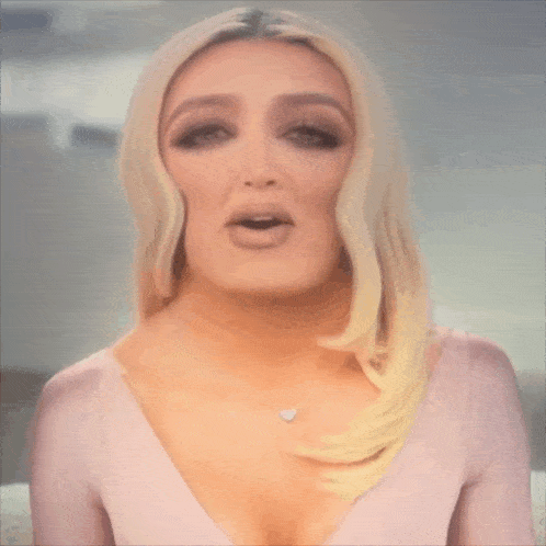 a woman in a pink dress with a heart necklace on her neck