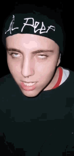 a young man wearing a black beanie with the word peep on it