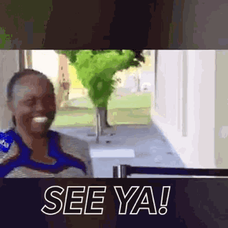 a woman is standing in front of a window and says see ya