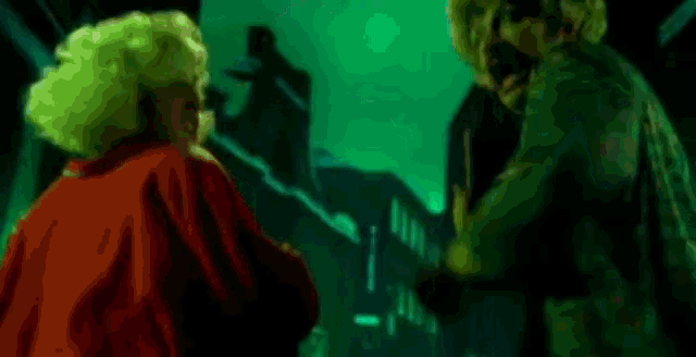 a couple of people standing next to each other in a dark room .