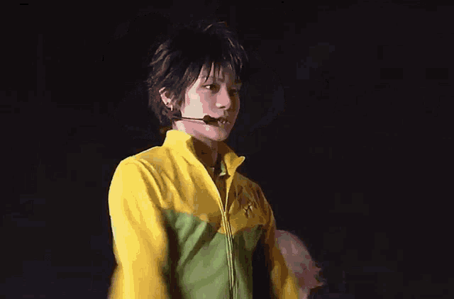 a person in a yellow and green jacket with a microphone on their head