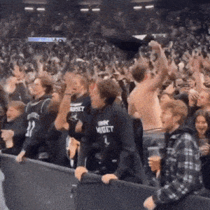 a man wearing a sweatshirt that says wiset stands in the crowd