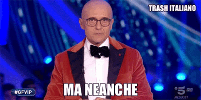 a man in a red suit and bow tie says ma neanche on the screen