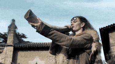 a woman is blowing a horn in front of a church