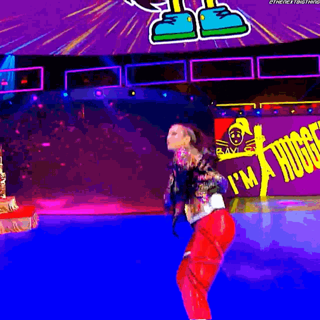 a woman is dancing in front of a sign that says i 'm a huge