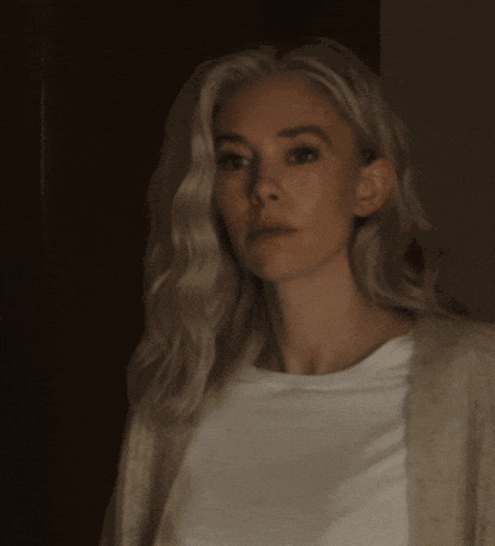 a woman with blonde hair is wearing a white shirt