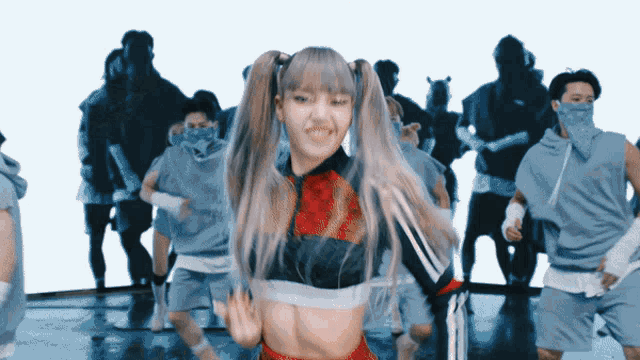 a woman with pigtails is dancing in front of a crowd of people