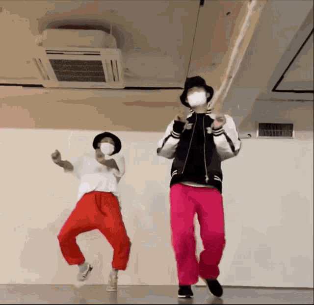 a man and a woman wearing masks are dancing together