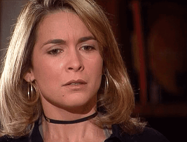 a woman wearing a choker and hoop earrings has a tear coming out of her eye