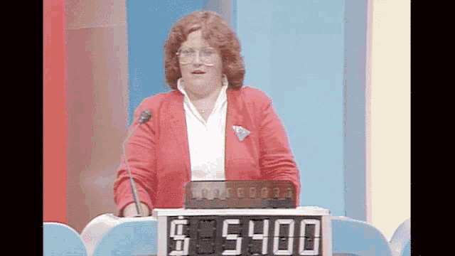 a woman in a red jacket stands in front of a sign that says $ 5,400