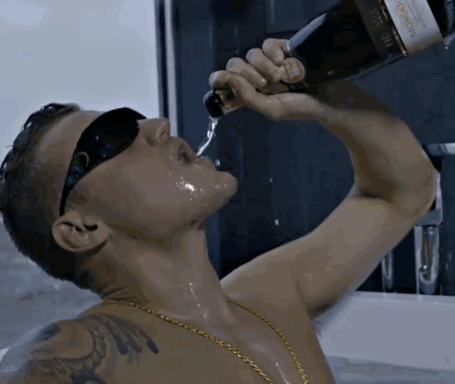 a man drinking from a bottle of moscato