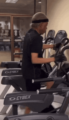 a man is riding an exercise bike that says cybex on it