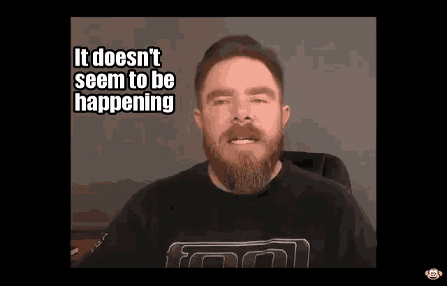 a man with a beard is sitting in a chair and says it does n't seem to be happening
