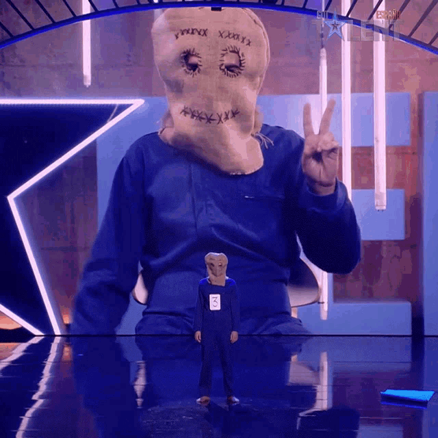 a man with a scarecrow mask on his head giving a peace sign