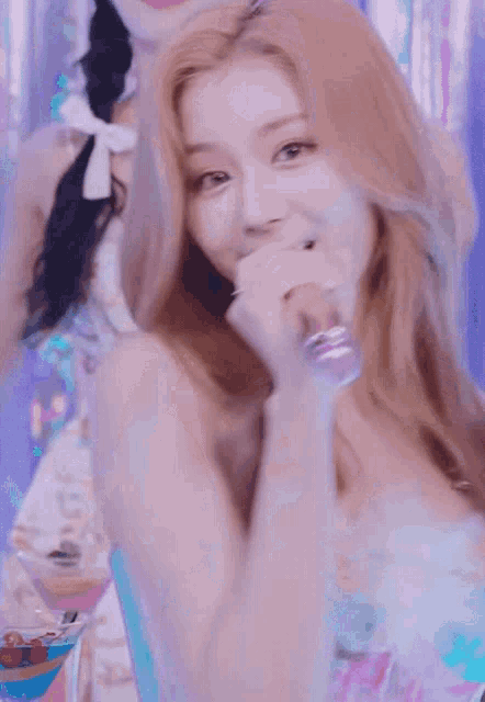 a woman is holding a microphone in her hand and smiling .