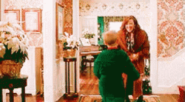 a man in a green jacket is kneeling down in front of a woman .