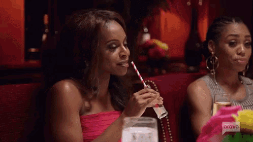 a woman is drinking through a straw at a party .