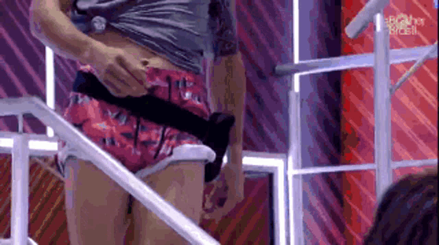 a woman in shorts is standing on a set with her shirt off