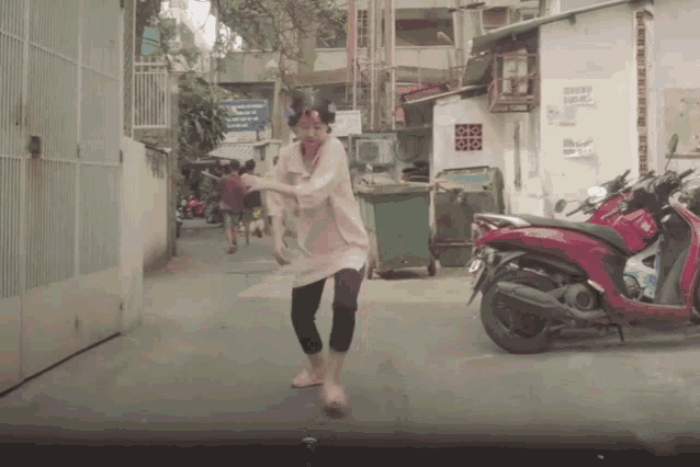 a red honda scooter is parked next to a woman