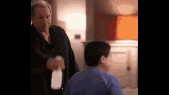 two men are standing next to each other in a living room .