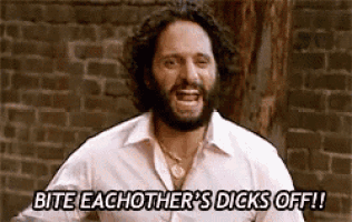 a man with a beard is standing in front of a brick wall and yelling .