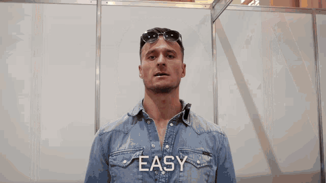 a man wearing sunglasses is surrounded by flames and the word easy is visible