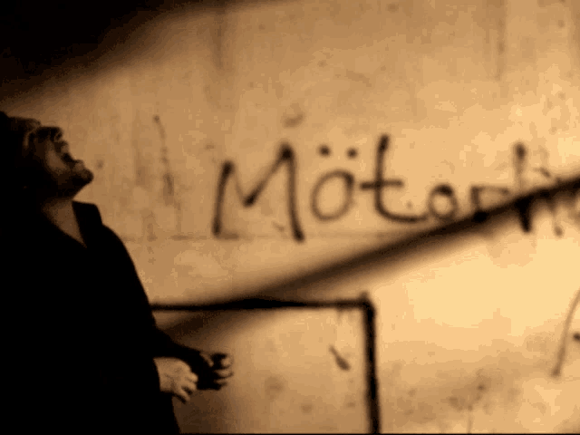 a person is standing in front of a wall that has the word motart written on it