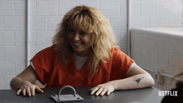 a woman sits at a table with a netflix logo on the bottom