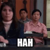 a group of people sitting at a table with a sign that says hah .