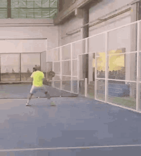 a man is playing paddle tennis on a court .