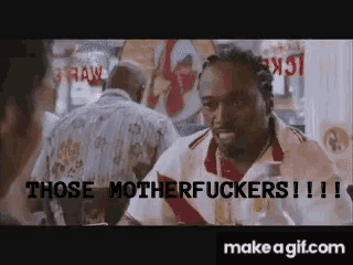 a man sitting at a table with the words " those motherfuckers !!! " on the bottom
