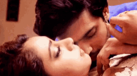 a man is kissing a woman on the forehead