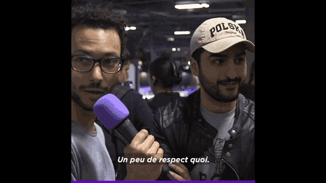 a man wearing a polo hat is holding a microphone