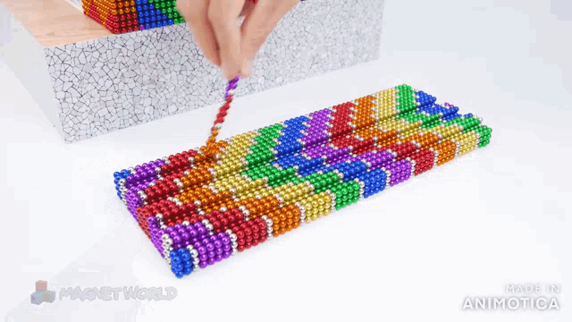 a person is playing with a bunch of colorful magnets that are made in animatica