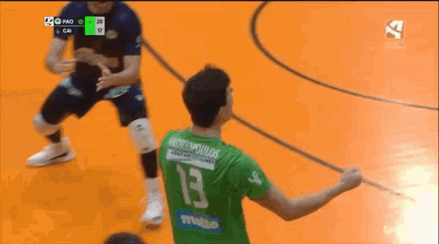 a man wearing a green jersey with the number 13