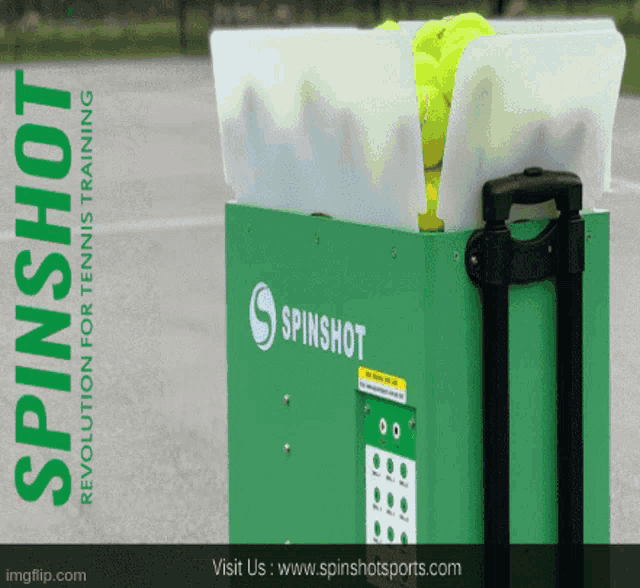 a green spinshot machine is filled with tennis balls