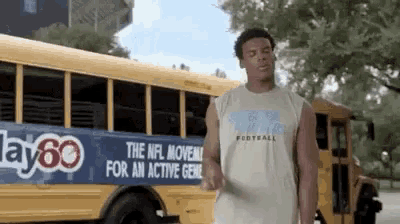 a man is standing in front of a yellow school bus that says the nfl moves for an active gen