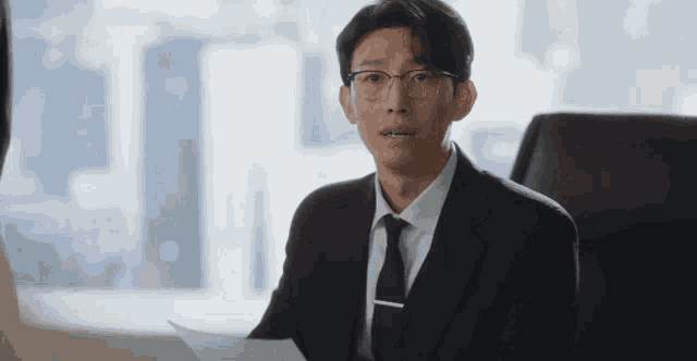 a man in a suit and tie is looking at a piece of paper