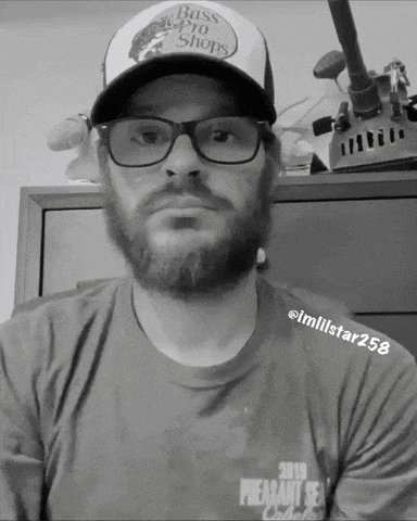 a black and white photo of a man wearing a hat that says bass pro shops