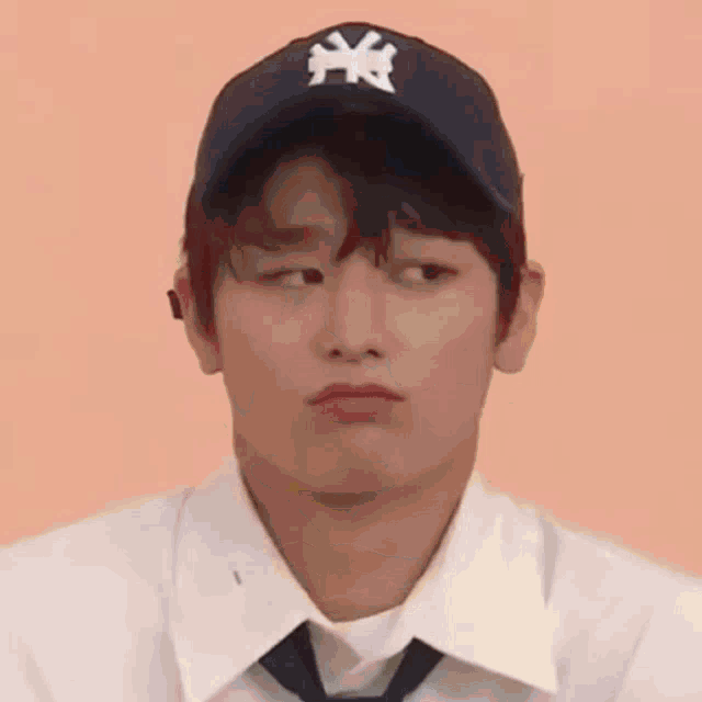 a close up of a person wearing a baseball cap and tie .