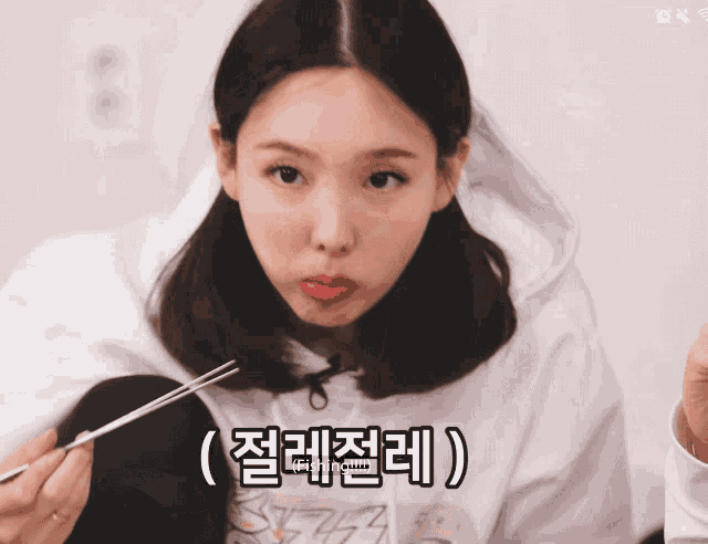 a woman holding a pair of tweezers with korean writing on the bottom