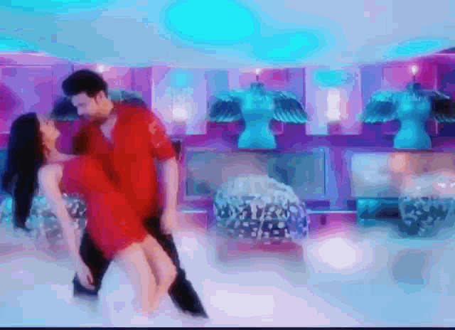 a man and a woman are dancing together in a room with mannequins .