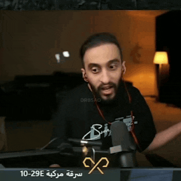 a man with a beard is sitting in front of a microphone with the number 10-29e on the bottom