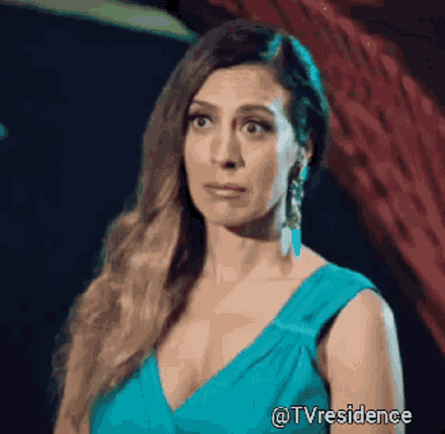 a woman in a blue dress is looking at the camera with the hashtag tvresidence
