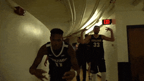 a basketball player wearing a number 33 jersey is walking down a hallway
