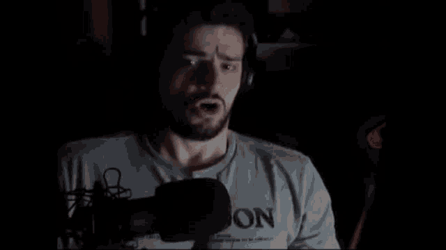 a man with a beard is wearing headphones and a shirt that says " no " on it