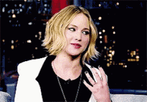 a woman with a ring on her finger is wearing a black and white jacket