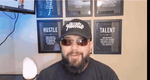 a man wearing sunglasses and a hat that says hustle on it