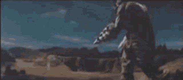 a man and a monster are fighting each other in a field with a light coming from the monster .